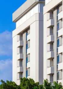 Immeuble d'appartements urbain élégant avec un ciel bleu clair en arrière-plan.